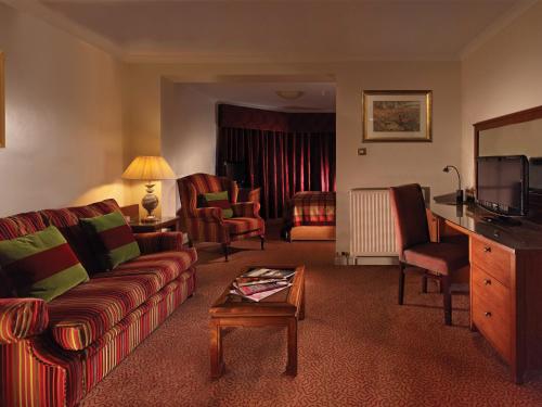 a living room with a couch and a tv at Macdonald Inchyra Hotel & Spa in Falkirk