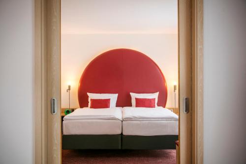 a bedroom with a bed and a dresser at ARCOTEL Rubin - im Szeneviertel St Georg in Hamburg