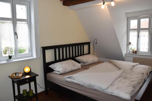 Bett in einem Zimmer mit 2 Fenstern in der Unterkunft Ferienwohnung Veste Heldburg in Bad Rodach