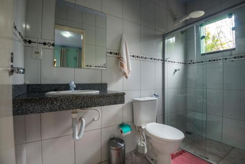 y baño con aseo, lavabo y ducha. en Pousada Bela Vista do Capão en Vale do Capao