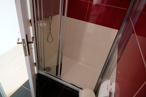a glass shower in a bathroom with a toilet at Casa da Laurindinha in Ponte de Lima