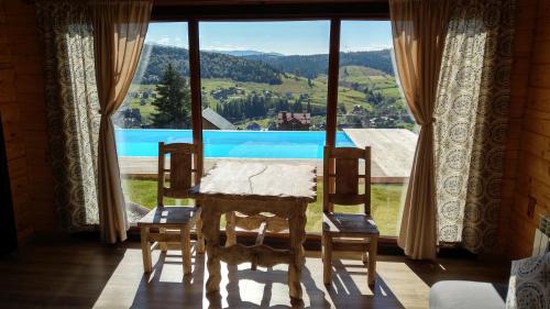 a room with a table and chairs and a large window at Vysche Neba in Bukovel