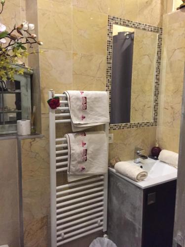 La salle de bains est pourvue d'un sèche-serviettes et d'un lavabo. dans l'établissement Chambre et salle de bain cocooning labellisée, à Nice