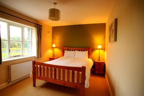 um quarto com uma cama grande e uma janela em Bunratty Holiday Homes em Bunratty