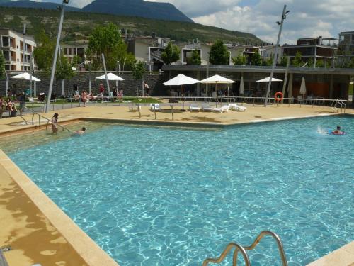 a large swimming pool with people in the water at APARTMENTSUITESPAIN FORMIGAL ORDESa in Sabiñánigo