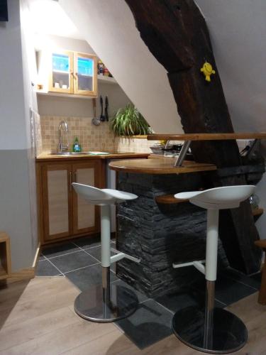 une cuisine avec un comptoir et deux tabourets de bar dans l'établissement La Musette, à Dijon