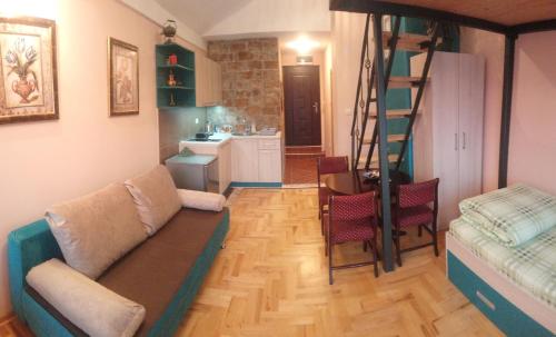 ein Wohnzimmer mit einem Sofa und einer Treppe in der Unterkunft Bolonja in Užice