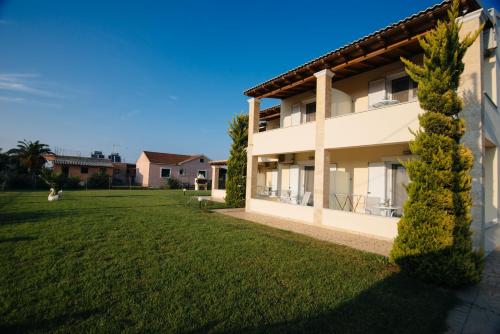 uma casa com um jardim verde em frente em Villa Agiolina em Sidari