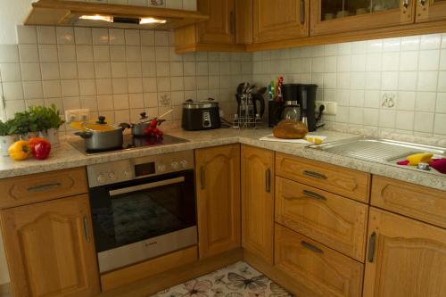 a kitchen with wooden cabinets and a stove top oven at Ferienhaus Betty in Rhauderfehn