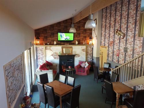 ein Wohnzimmer mit einem Tisch und Stühlen sowie einem TV in der Unterkunft The Boe Rigg in Hexham