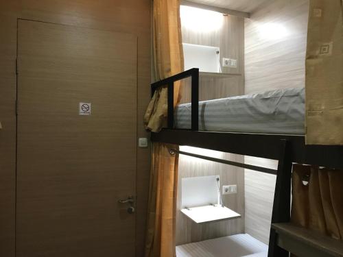 a room with two bunk beds and a door at The Colour Hostel in Pontianak