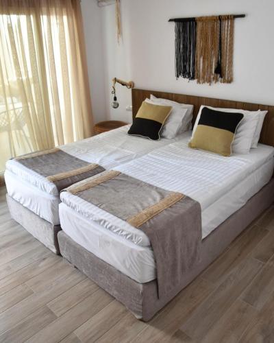 a bedroom with two large beds with pillows at Angelos Boutique Suites in Patitiri