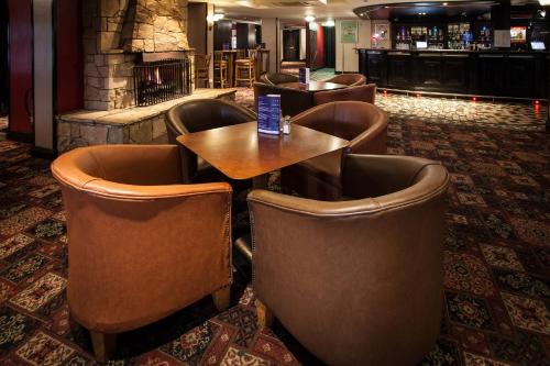a bar with leather chairs and tables in a restaurant at Strangford Arms Hotel in Newtownards