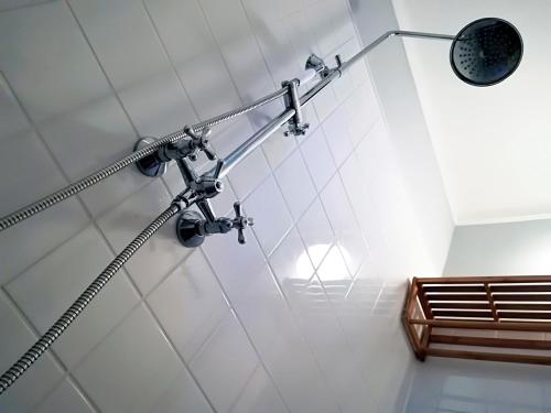 a shower stall with a light on the wall at Postaláda vendégház in Salföld