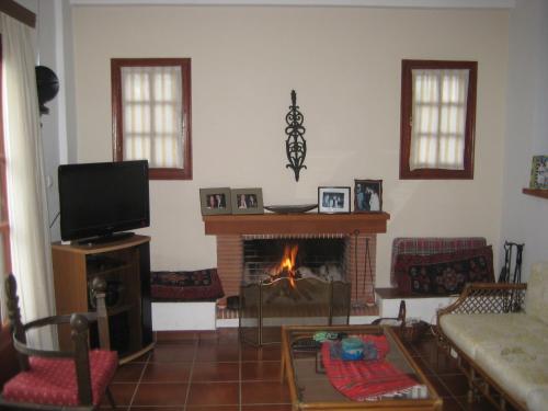 a living room with a fireplace and a tv at Beautiful Villa in Koukounara in Pylos