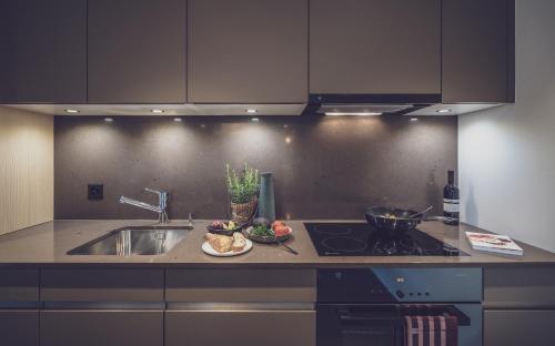 a kitchen with a sink and a counter top at Parsenn Resort in Davos