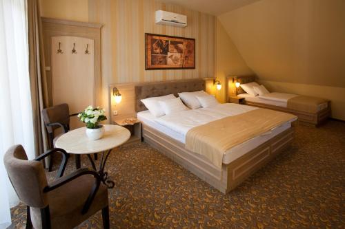 Postel nebo postele na pokoji v ubytování Barokk Hotel Promenád