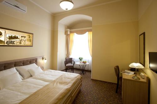 a hotel room with a bed and a desk at Barokk Hotel Promenád in Győr