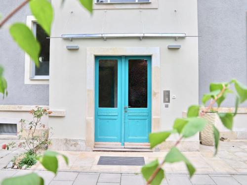 eine blaue Tür in einem weißen Gebäude in der Unterkunft Residenz am Dresdner Stadtwald in Dresden