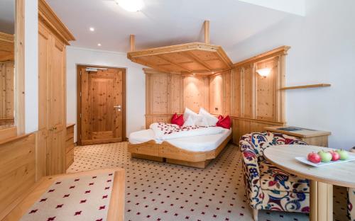 a bedroom with a bed and a table in a room at DAS BADL - Smart Retreat AO in Caldaro