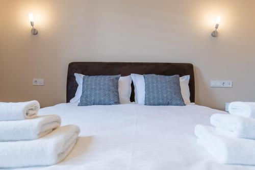 a bedroom with a bed with white sheets and blue pillows at Pensiunea Select Central in Târgu-Mureş