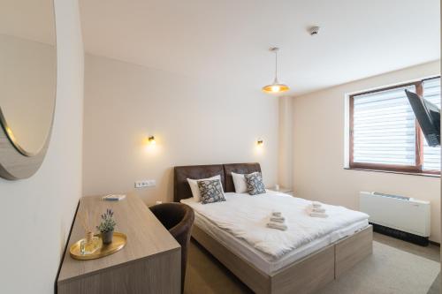 a small bedroom with a bed and a desk at Pensiunea Select Central in Târgu-Mureş