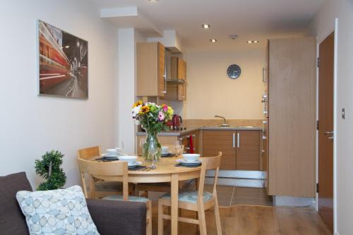 uma sala de jantar e cozinha com mesa e cadeiras em Royal Crossharbour Apartment em Londres