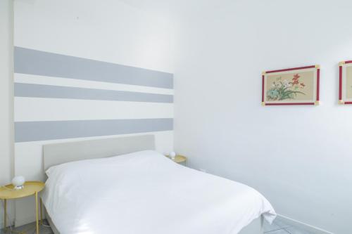 a bedroom with a white bed and a yellow table at Central cosy apartment in Bologna