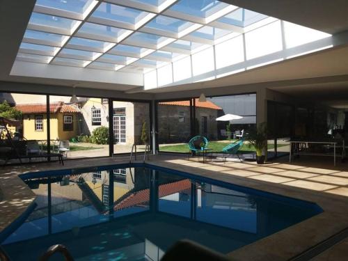 a swimming pool in a house with a glass ceiling at Solar dos Correia Alves in Moimenta da Beira