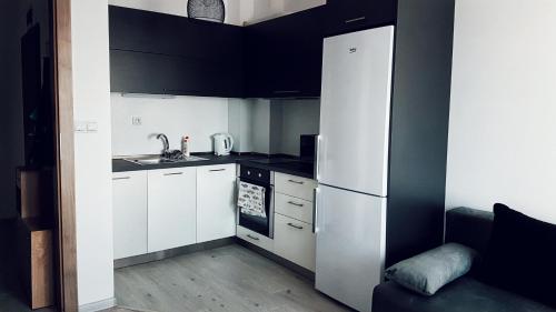 a small kitchen with white cabinets and a refrigerator at Apartment Valerie walking distance to Top Center in Plovdiv