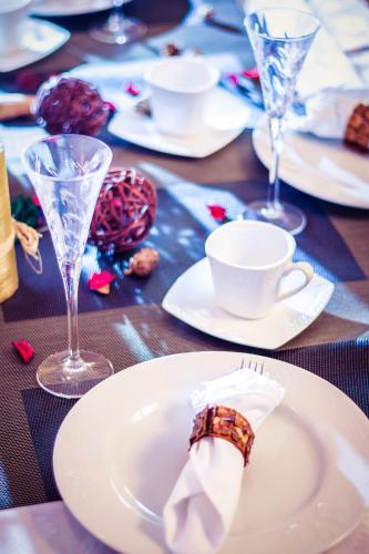 a table with white plates and wine glasses on it at Apartments Bogdanovic in Kotor