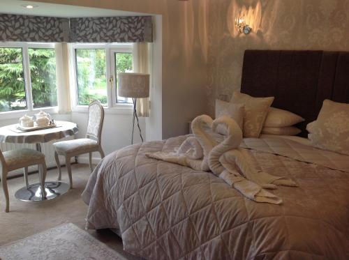 Un dormitorio con una cama grande con un animal de toallas. en Oakleigh house en Stratford-upon-Avon