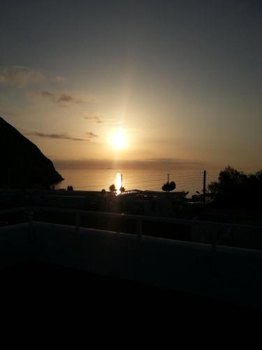 a sunset over the ocean with the sun in the sky at Sagma Beach Rooms in Perissa
