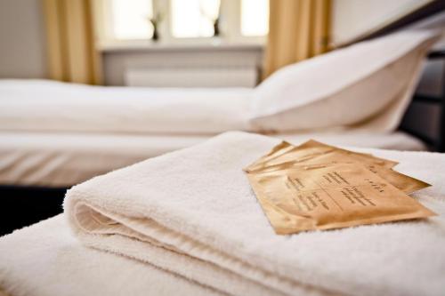 a piece of paper sitting on top of a bed at Sleep in Hostel & Apartments Stary Rynek in Poznań