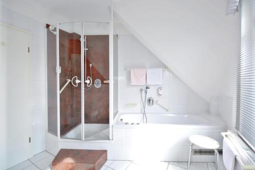 a white bathroom with a shower and a sink at Hotel Jugendstil in Hameln