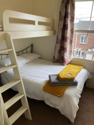 a bedroom with a bunk bed next to a window at The Leeman Rose in York