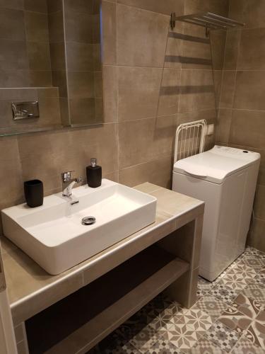 a bathroom with a white sink and a toilet at Fantastic Four Apartments in Neoi Epivates