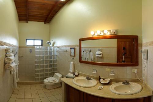 a bathroom with two sinks and a mirror at Cristal Ballena Boutique Hotel & Spa in Uvita