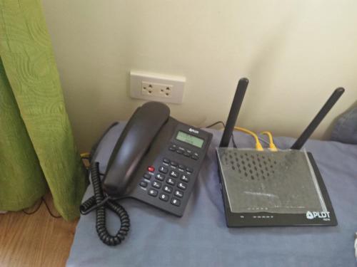 a telephone and a laptop on a bed at Stay at Sanremo Oasis Cebu in Cebu City