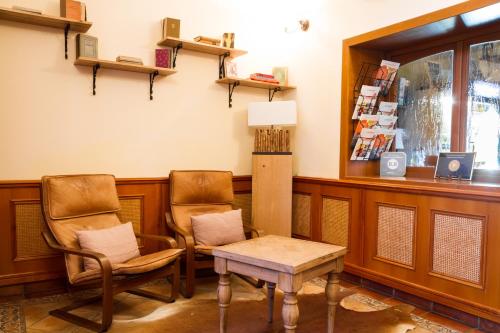 a waiting room with two chairs and a table at Hangya Panzió és Étterem in Csepreg