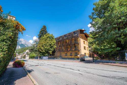 una strada vuota di fronte a un edificio di Hôtel Le Marintan a Saint-Michel-de-Maurienne