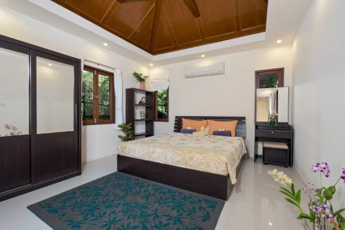 a bedroom with a bed and a mirror at Villa Liu in Nathon