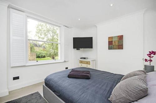 Habitación blanca con cama y ventana en Bright Luxurious Flat in Little Venice en Londres