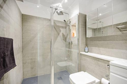 a bathroom with a shower and a toilet and a sink at Bright Luxurious Flat in Little Venice in London