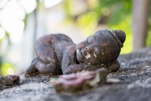 a statue of a teddy bear laying on the ground at Villa Liu in Nathon