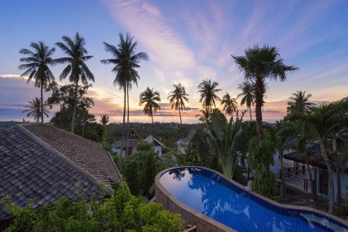 a view of a resort with a swimming pool and palm trees at Villa Liu in Nathon