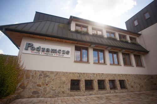 a building with a sign on the side of it at Podzamcze in Rożnów