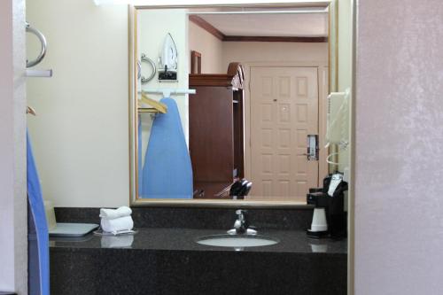 a bathroom with a sink and a large mirror at Sanger Inn in Sanger