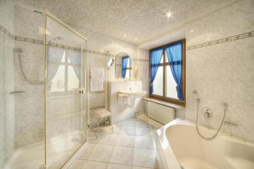 ベルンカステル・クースにあるホテル ツル ポストの浴槽、シャワー、洗面台を備えたバスルーム