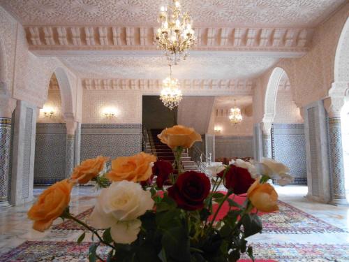 a room with a vase of flowers and a chandelier at Dar Nador in Nador